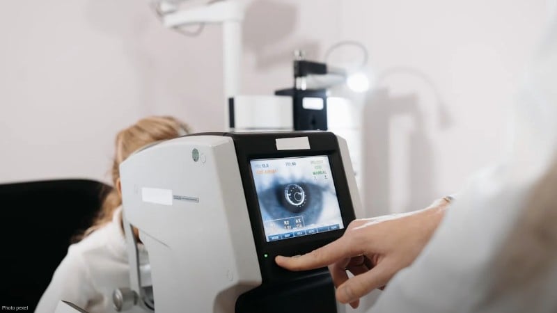 Close-up of an ophthalmologist using a device for an eye exam in a medical clinic setting., tags: landmark telemedicine - pexel